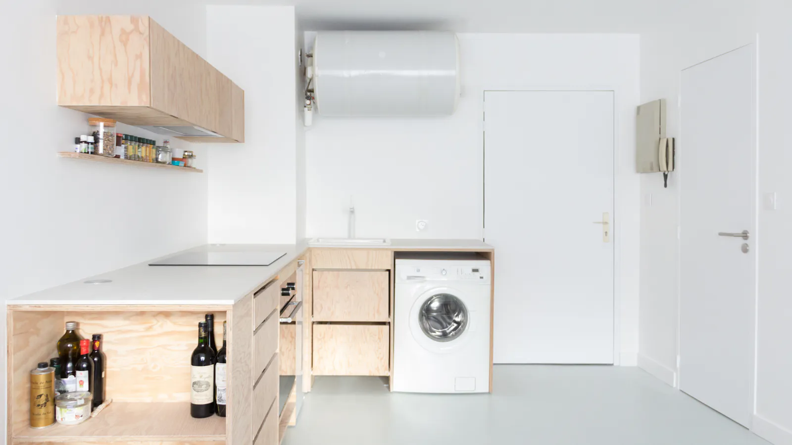 Cugnaux — Studio rénové, cuisine en bois clair et porte d’entrée sur murs blancs