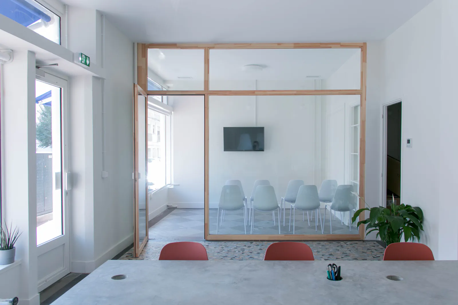 Larousse — Salle de cours vitrée à structure en pin, vue depuis l’accueil