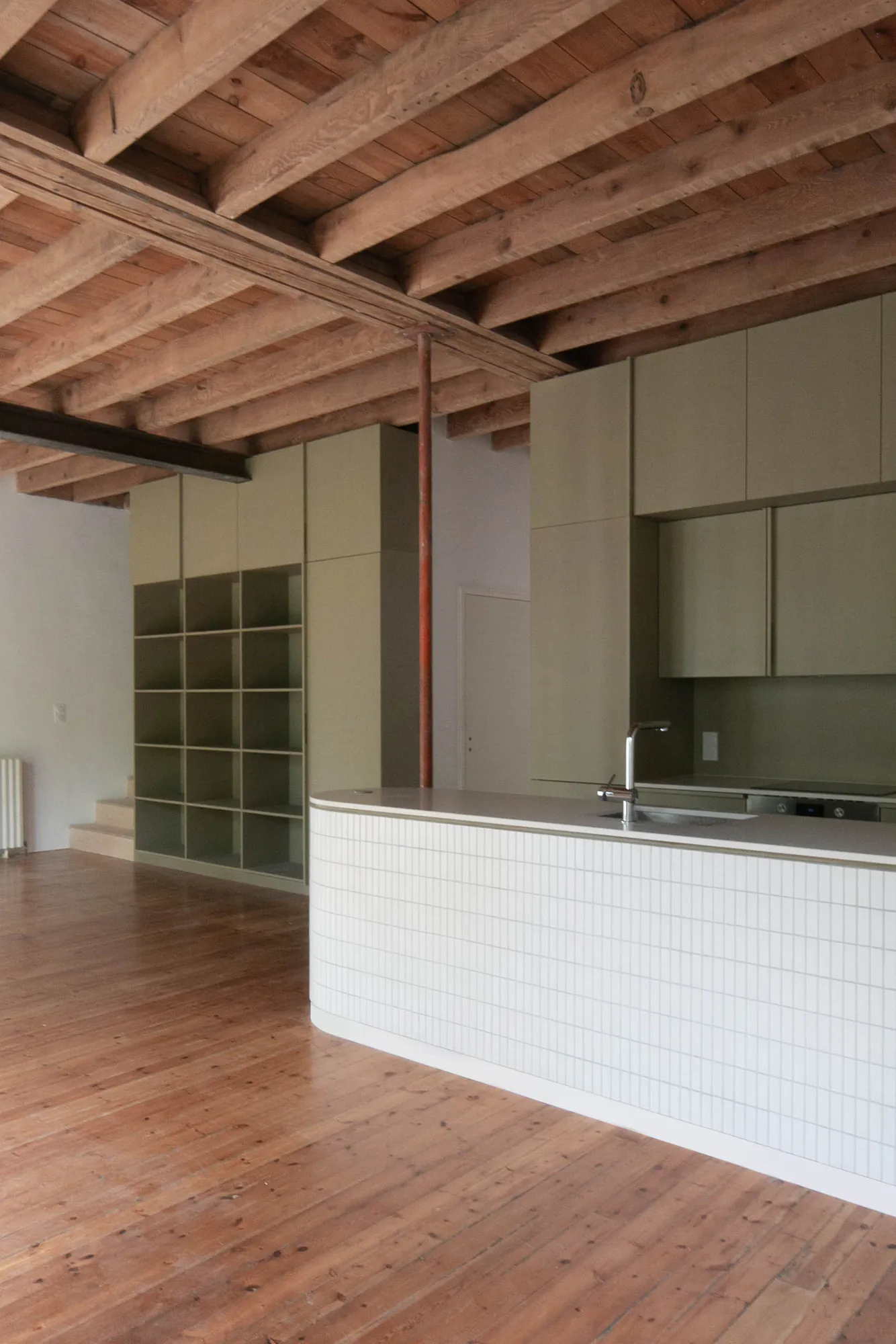 Negreneys — Cuisine ouverte sous plancher bois apparent, îlot blanc et meubles kaki