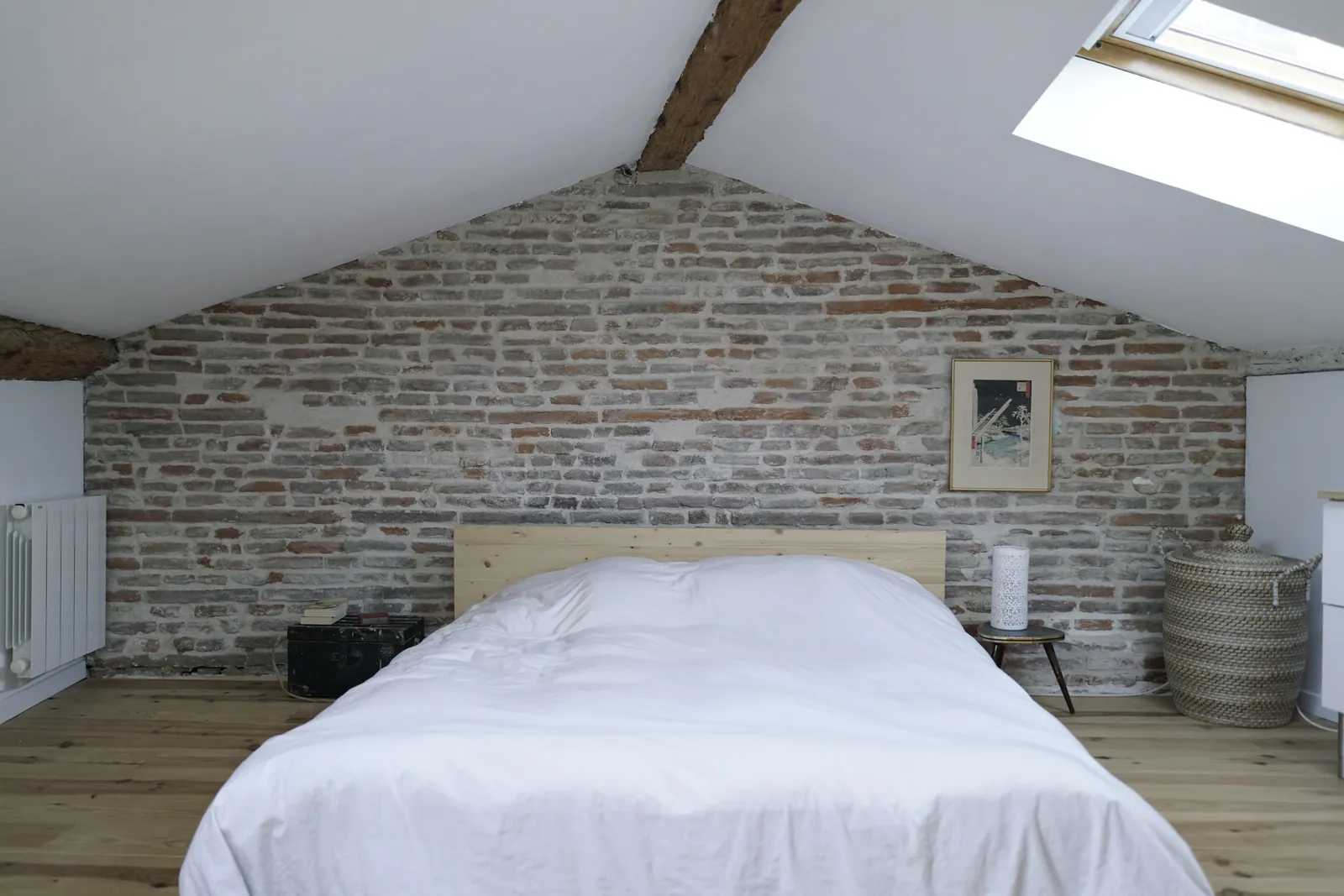 République — Chambre sous combles, mur de brique et lit blanc